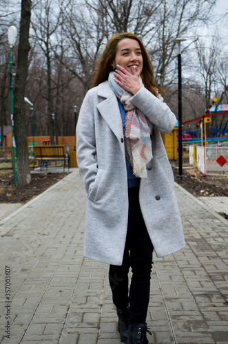 The girl is walking in the park. Read a book.