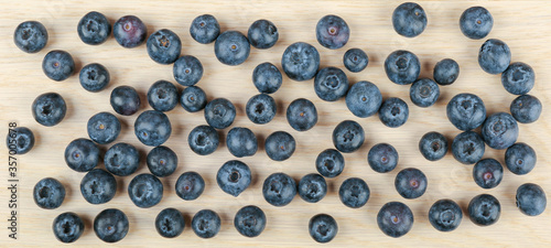  blueberry berries on light wooden background top view