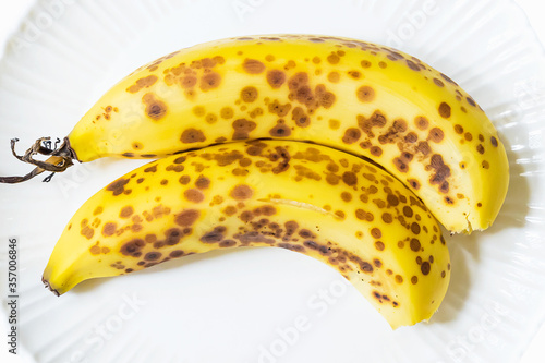 Ripe Cavendish banana with brown spots on white dish