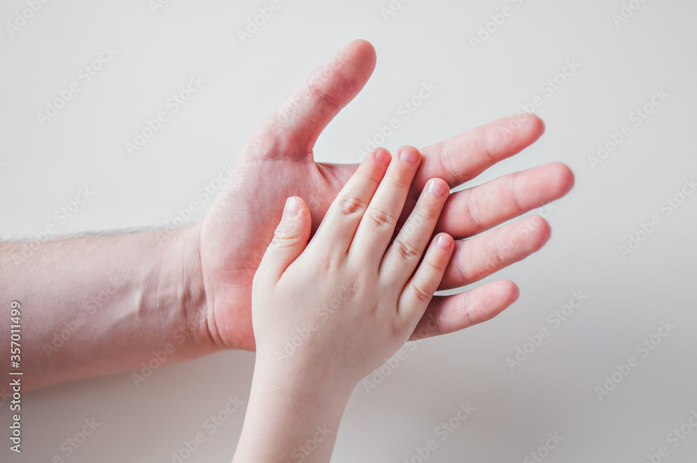 Hands of a father and child on a white background. Hands of a father and child on a white background.