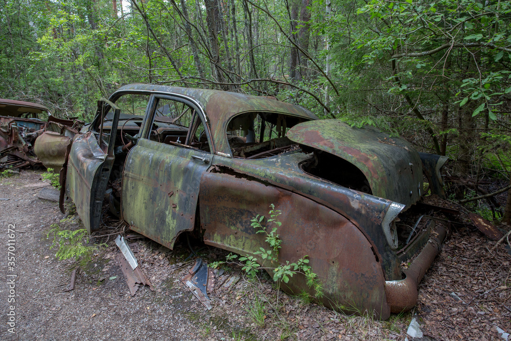 Old cars in Sscrapyard in forest in Ryd Sweden