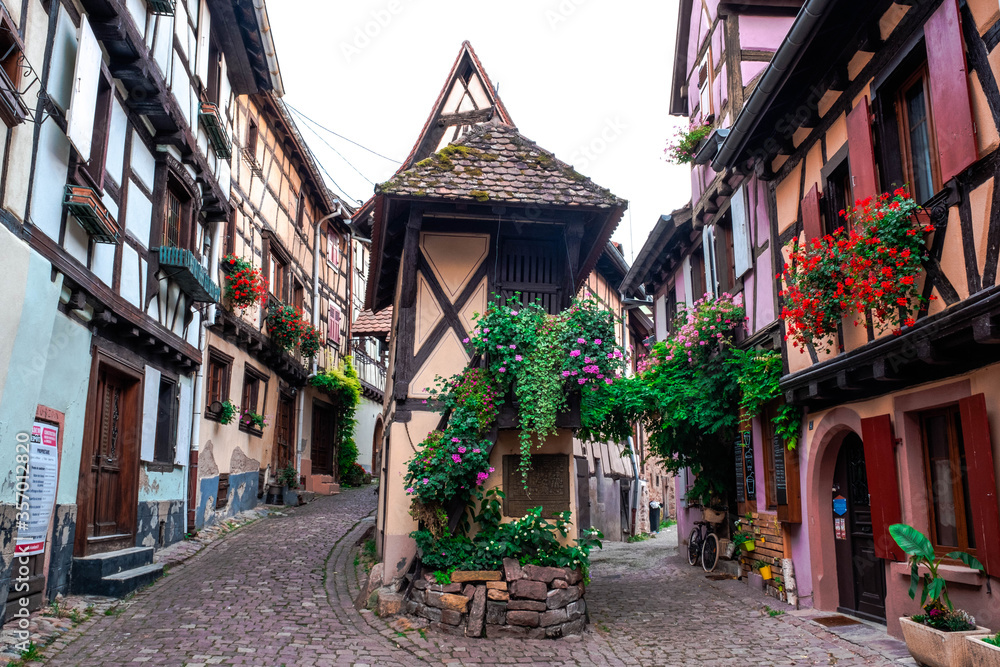 A street in Eguisheim, Alsace, France, with historic buildings and typical Alsatian architecture A street in Eguisheim, Alsace, France, with historic buildings and typical Alsatian architecture