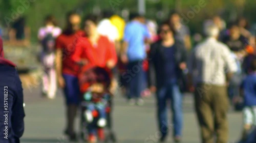 Anonymous crowd of people strolling slowly along the seaside. Generic people wander around aimlessly like shadows

