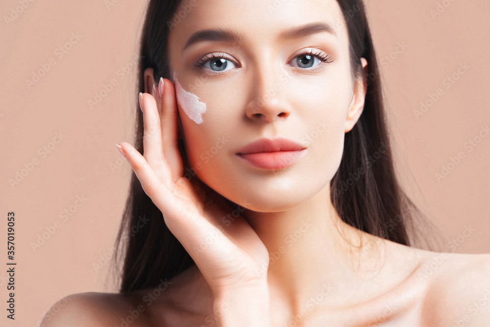 Young beautiful woman apply cream on clean perfect skin Young beautiful woman apply cream on clean perfect skin