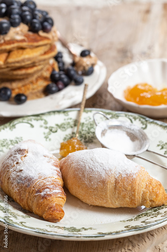 Two croissants in a ceramic plate with green pattern