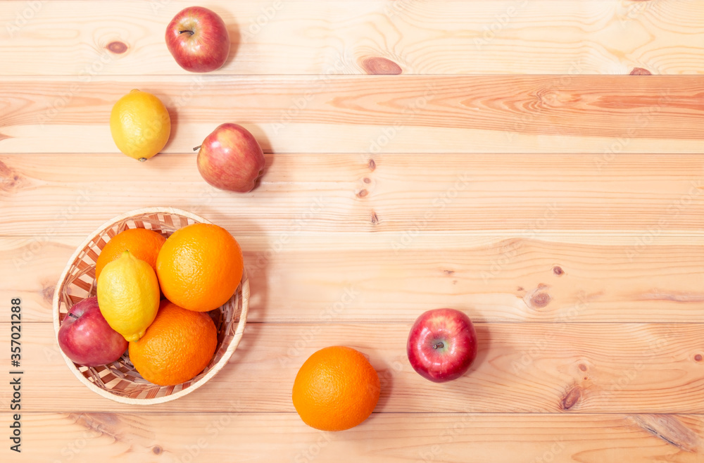 Oranges, apples and lemons in wicker basket and near. Selective focus. Top view, copy space. Oranges, apples and lemons in wicker basket and near. Selective focus. Top view, copy space.