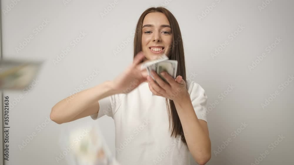 Rich and beautiful business successful woman with a beautiful smile scattering money 100 dollar bills. Salary. Happy worker Rich and beautiful business successful woman with a beautiful smile scattering money 100 dollar bills. Salary. Happy worker