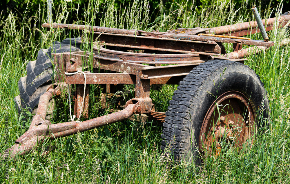 Old rusty trailer standing abandoned in an overgrown meadow Old rusty trailer standing abandoned in an overgrown meadow