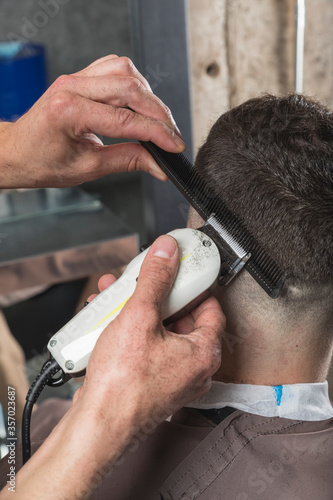 hombre peluquero cortando el pelo a cliente