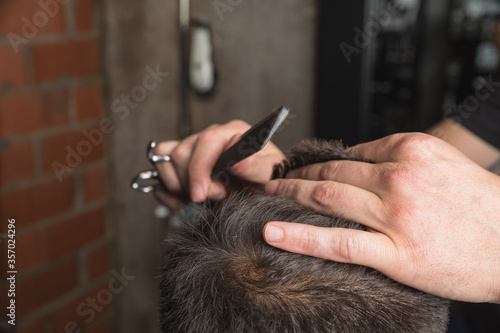 hombre peluquero cortando el pelo a cliente