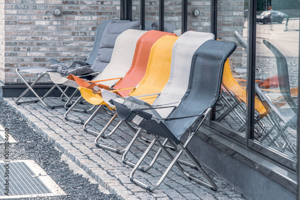 Get ready for summer. Colorful folding  outside chairs lined up in front of the furniture shop. Perfect for people who will spend their summer holidays at home.