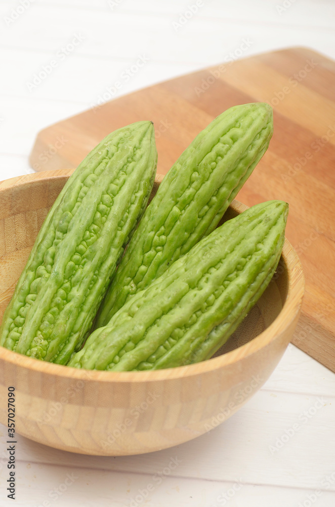 sliced bitter melon, Peria, Pare, vegetables in wooden bowl sliced bitter melon, Peria, Pare, vegetables in wooden bowl