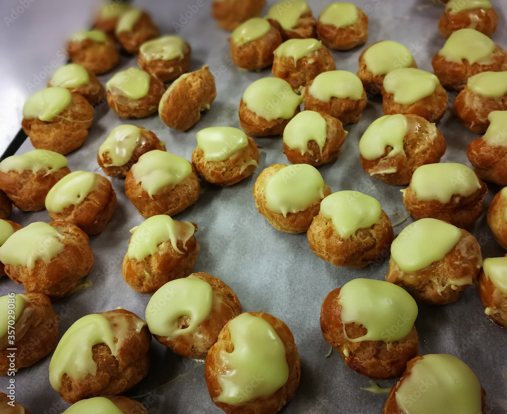 Close up French dessert eclairs with filling and pistachio glazes. Backgrounds Close up French dessert eclairs with filling and pistachio glazes. Backgrounds