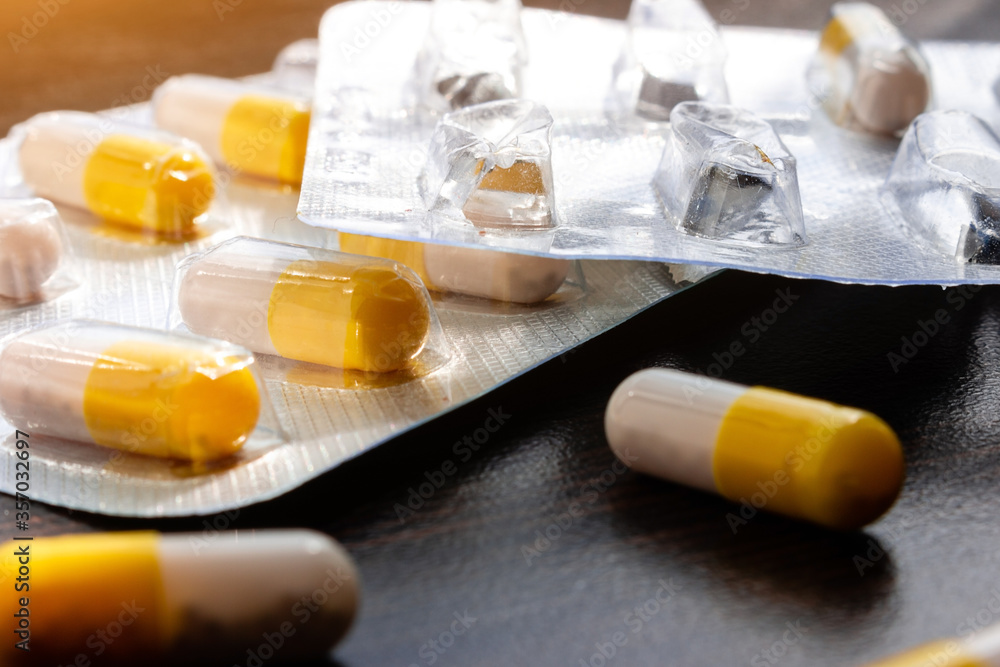 capsule-shaped tablets and their packaging close-up selective focus capsule-shaped tablets and their packaging close-up selective focus
