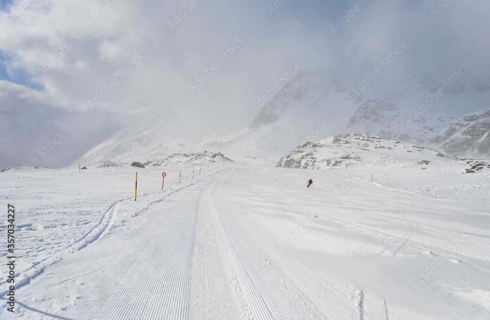 Spring alp scenery from Molltal glacier. Ski slope with skier in foggy april day.