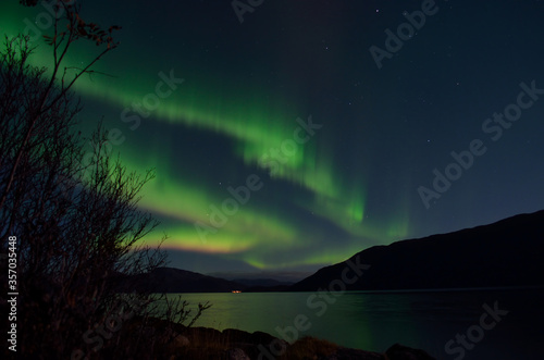 beautiful aurora borealis dancing over mountain and fjord landscape on late autumn night in northern Norway © Arcticphotoworks