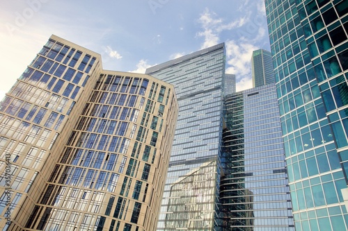 Office and residential skyscrapers on bright sun and clear blue sky background. Commercial real estate. Modern business city district. Office buildings exterior. Financial city district. City downtown
