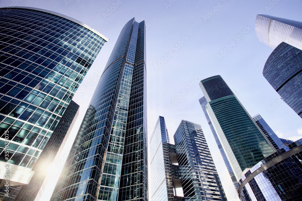 Office and residential skyscrapers on bright sun and clear blue sky background. Commercial real estate. Modern business city district. Office buildings exterior. Financial city district. Downtown.