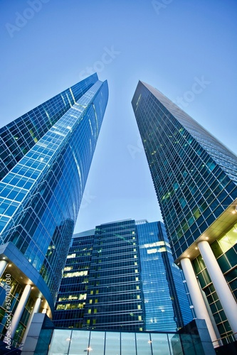 Office and residential skyscrapers on bright sun and clear blue sky background. Commercial real estate. Modern business city district. Office buildings exterior. Financial city district. Downtown.