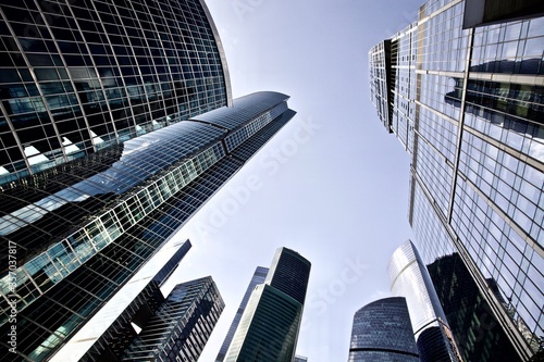 Office and residential skyscrapers on bright sun and clear blue sky background. Commercial real estate. Modern business city district. Office buildings exterior. Financial city district. Downtown.