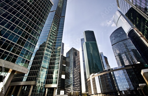 Office and residential skyscrapers on bright sun and clear blue sky background. Commercial real estate. Modern business city district. Office buildings exterior. Financial city district. Downtown.