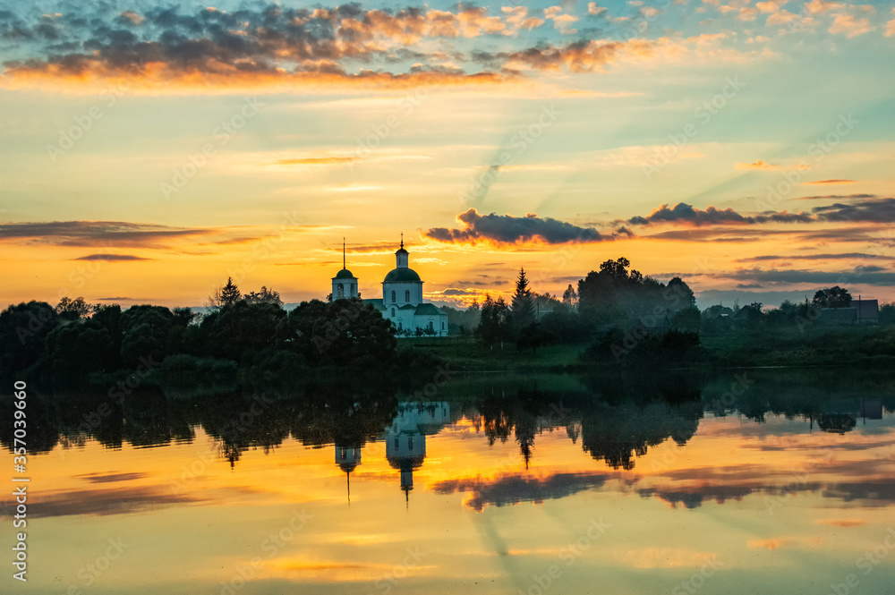reflection of the forest and church in the lake water at sunset in summer reflection of the forest and church in the lake water at sunset in summer