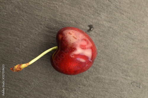 Ripe juicy organic sweet cherry, close-up, on a serving plate of slate.