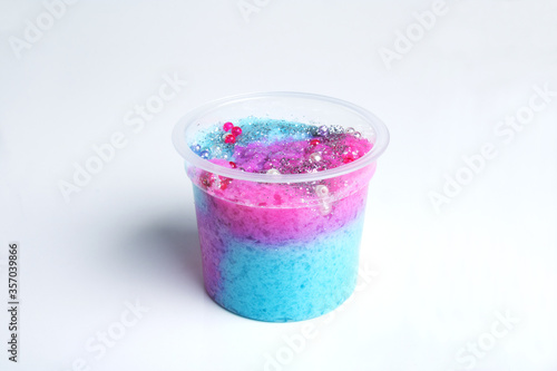 Boxes of colored slime with decorations over light background. Children fun and leisure activities. 