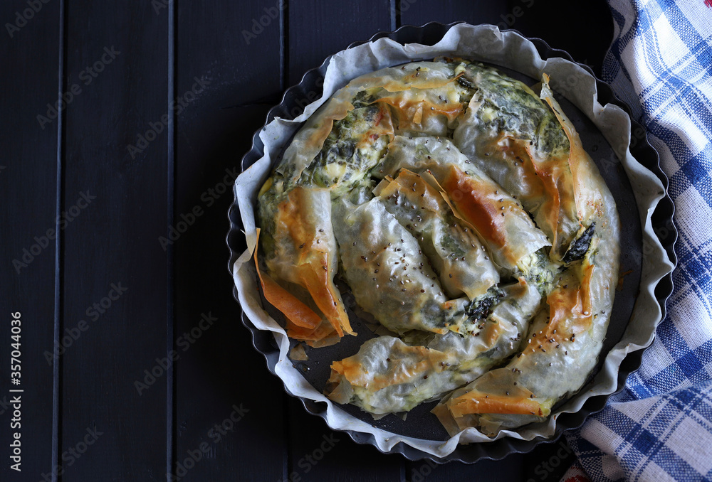 Concetto di cucina greca. Spanakopita arrotolata, torta greca della