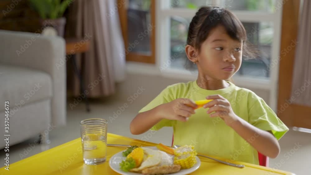 cute little girl having healthy breakfast at home by herself