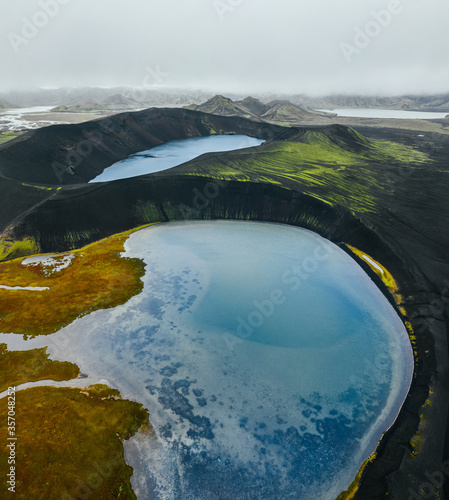 Epic landscape in Iceland. Blue crater lake on a background of black volcanic desert. Top view by drone. Vertical photo. photo