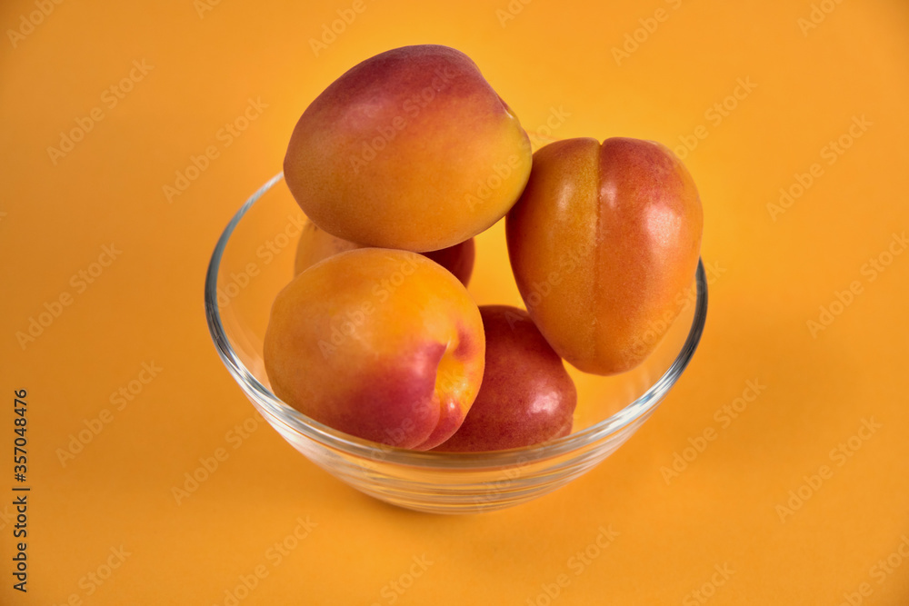 Fresh juicy apricots in a transparent glass plate. Macro. Fresh juicy apricots in a transparent glass plate. Macro.