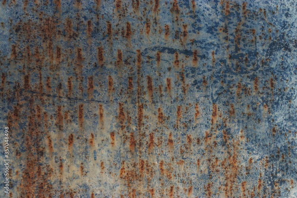 Background texture of concrete with corrosion and rusty metal. Sunlight falls to the surface and leaves a beautiful pattern. Doors and wall of an industrial building. Background texture of concrete with corrosion and rusty metal. Sunlight falls to the surface and leaves a beautiful pattern. Doors and wall of an industrial building.