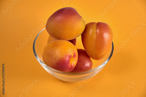 Fresh juicy apricots in a transparent glass plate. Macro.