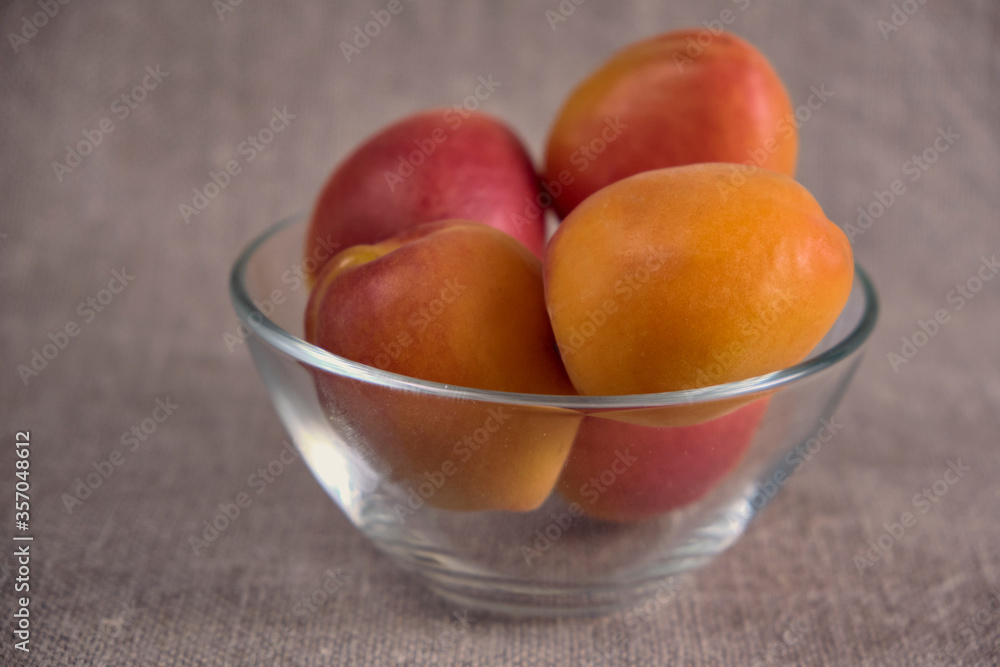 Fresh juicy apricots in a transparent glass plate. Macro. Fresh juicy apricots in a transparent glass plate. Macro.