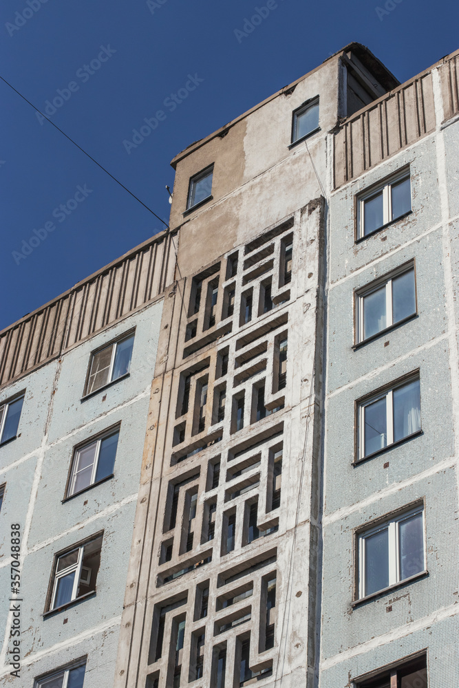 Old building of the twentieth century in the Russian city. The architecture of residential buildings in a minimalist style. A warm sunny day - a walk around the city.