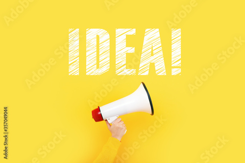 megaphone in hand and inscription idea on a yellow background