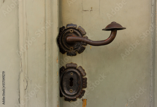 Stylized mushroom door handle. Ancient metal door knocker. Metal Hungarian handle. Vintage texture background.