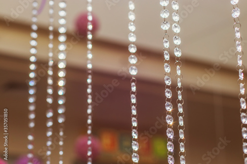 Long beads garland of glass as a decor in the premises of the shopping center. Multi-colored photos of the store.