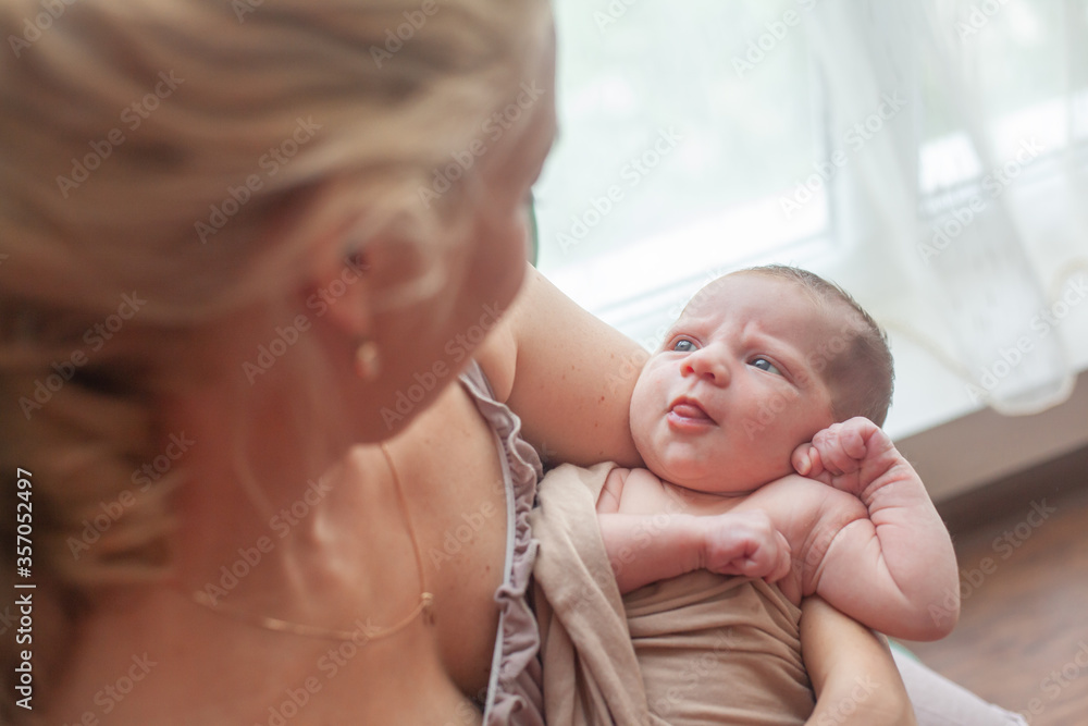 Young mother holding on hands newborn two weeks baby at home in the room. Home portrait of happy fаmily Young mother holding on hands newborn two weeks baby at home in the room. Home portrait of happy fаmily