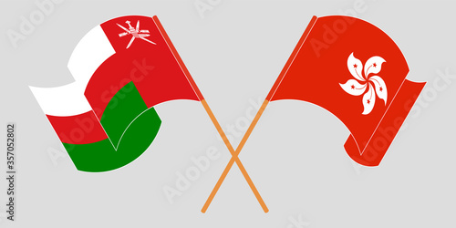 Crossed and waving flags of Oman and Hong Kong