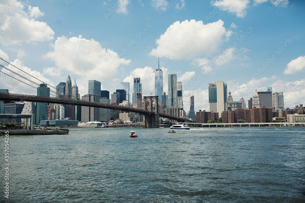 Hudson River and Brooklyn Bridge amid skyscrapers and large buildings of New York