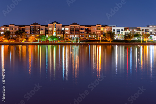 The multi-hued lights of stylish condos reflect off the calm waters of Tempe Town Lake in Arizona.