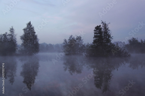 Early foggy morning on the lake in summer