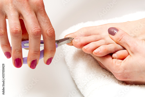 Home pedicure. Foot care treatment and nail. Young woman doing pedicure at home.