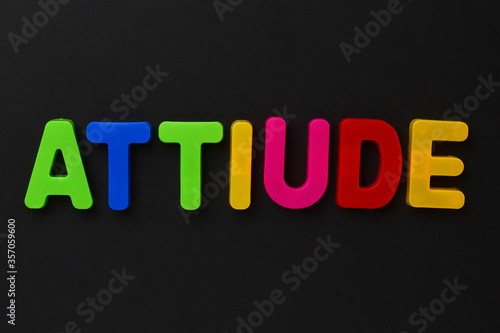 Text made in multicolored magnetic letters. ATTIUDE. Black photo