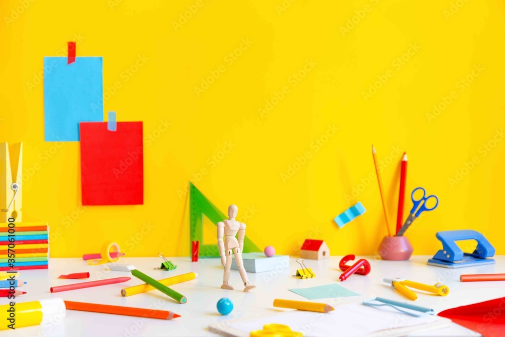 Back to school concept. School supplies dotted on a desk and yellow background copy space. Creative and abstract template. Back to school concept. School supplies dotted on a desk and yellow background copy space. Creative and abstract template.
