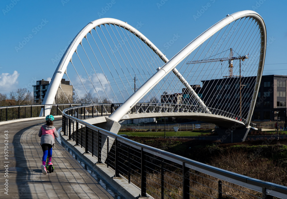 A young girl on a scooter on the Peter Courtney Minto Island Bridge, it connects Salem's Riverfront park to Minto Brown Park, Salem, Oregon A young girl on a scooter on the Peter Courtney Minto Island Bridge, it connects Salem's Riverfront park to Minto Brown Park, Salem, Oregon