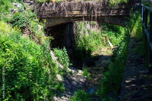 Old historical stone bridge in forest.