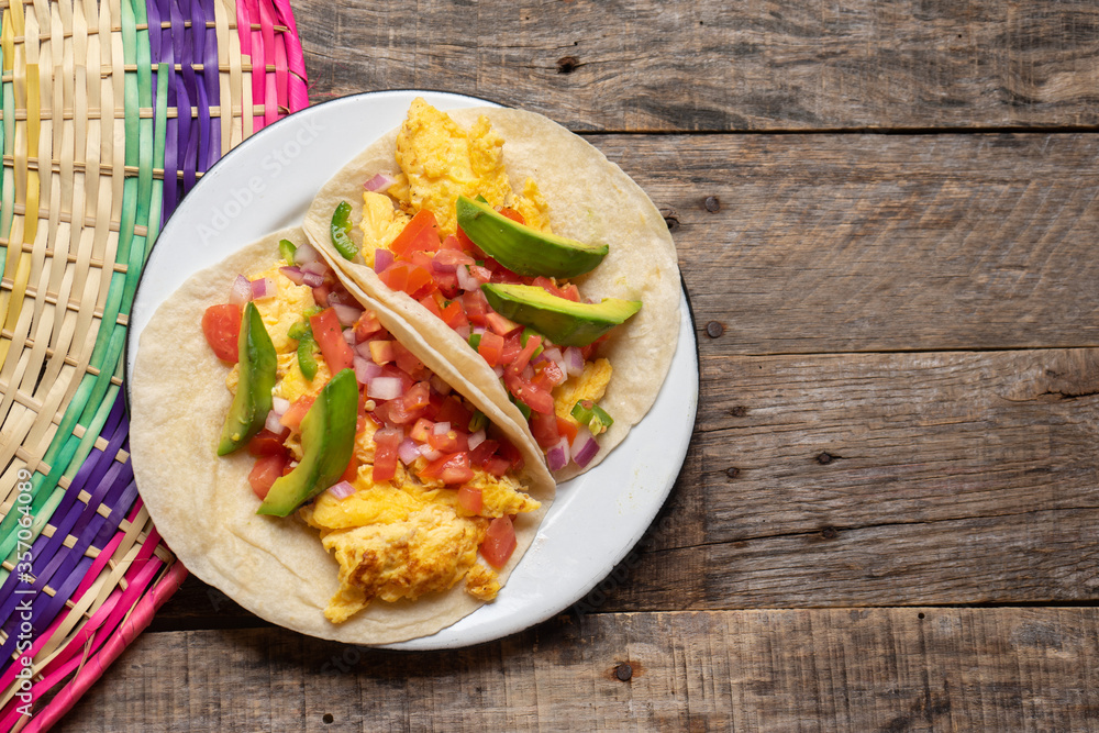 Breakfast egg tacos with flour tortilla and fresh sauce on wooden background Breakfast egg tacos with flour tortilla and fresh sauce on wooden background